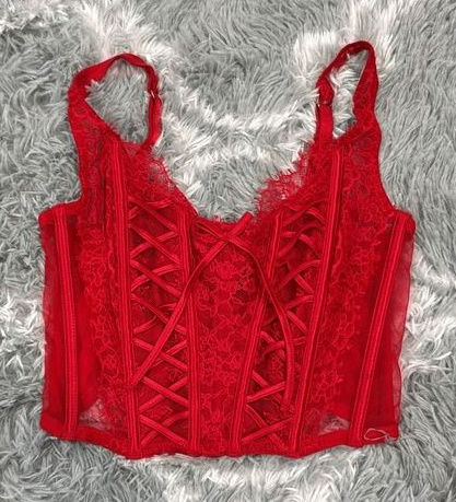 Bright red lace-up corset top with visible boning and lace texture.