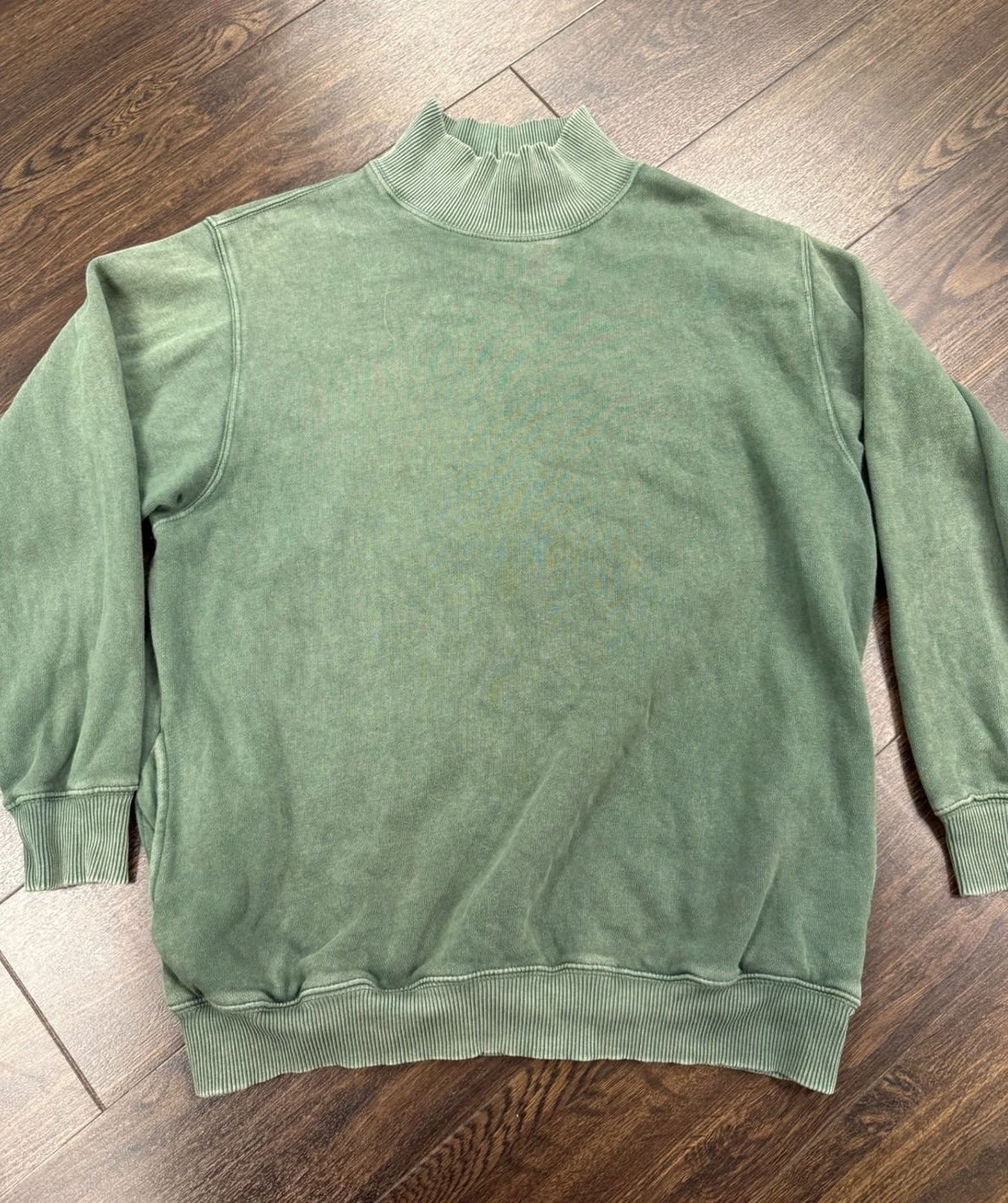 Sage-green mockneck sweatshirt laid flat, showing a wide body, dropped shoulders, and full sleeves.