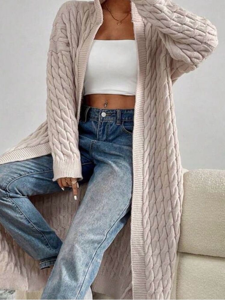 Chunky cream cable-knit cardigan styled with relaxed blue jeans.