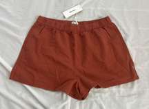 classic beach short  Size 12  Condition: NWT Color: reddish brown  Details : - 92% Recycled Polyester 8% Spandex - a timeless minimal cut from a buttery soft recycled polyester stretch fabrication  - Perfect for every day or the beach