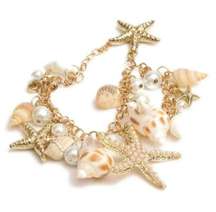 Beachy gold and white charm bracelet with starfish and seashells. NWT