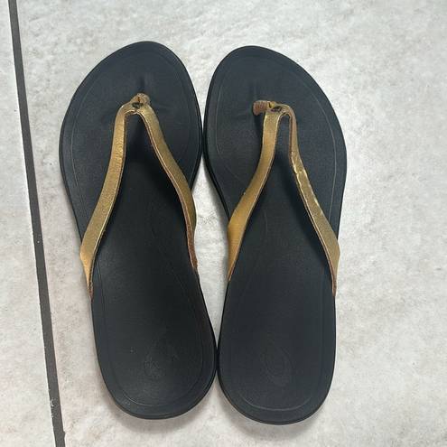 Olukai  Ho'Opio Womens Gold Black Slip On Thong Sandals