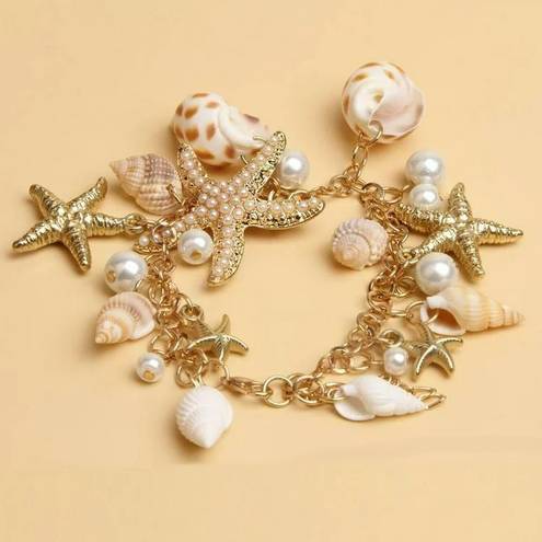 Jewelry by Lyra Beachy gold and white charm bracelet with starfish and seashells. NWT