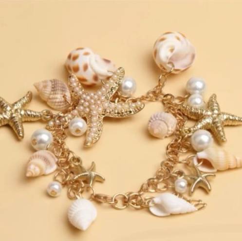 Jewelry by Lyra Beachy gold and white charm bracelet with starfish and seashells. NWT