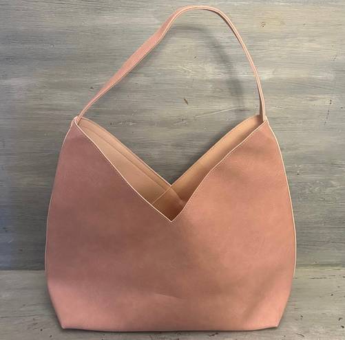 Hobo pink and tan shoulder bag with a unique asymmetrical design, featuring a side zipper closure