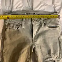 American Eagle Size 00 Super Strechy off white Jeans. Lots of Holes