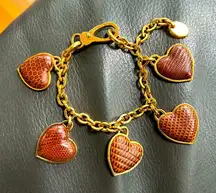 Tod’s heart charm bracelet in gold and brown leather.