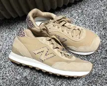 New Balance 515 sneaker in a beige/incense colorway with a leopard print "N" logo and heel tab accent. 