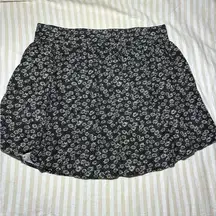 Cooperative black mini skirt with daisy flowers and pockets