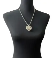 Silver colored heart locket necklace filled with rhinestones in the front side