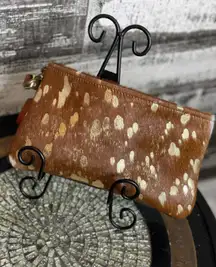 Brown cowhide with gold acid wash. 10”x6” wristlet with removable strap.