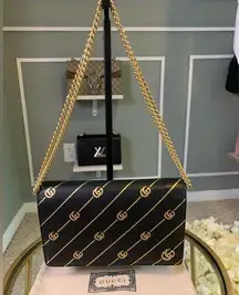 Gucci mini leather chain bag with double G stripe in black and gold.