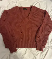 Marshall’s orangey red fall sweater 