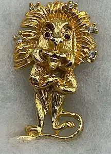 Vintage smirking lion arms crossed brooch.