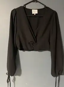This item is a black twist-front crop top with long bishop sleeves