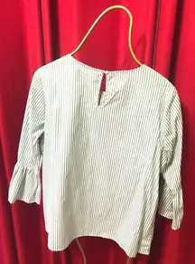 . Green/white stripped blouse with pearls in the front and flares on the sleeves.