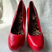 Vibrant red high heel shoes with an elegant and daring design.