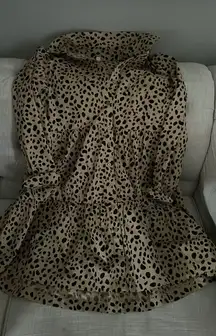 The dress combines elements of a classic shirt dress, with a collared neckline and button-down front, and a tiered or ruffle-bottom skirt