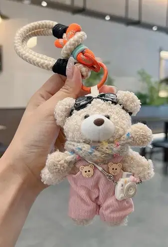 Adorable fluffy black monster keychain with big cartoon eyes and white feet.