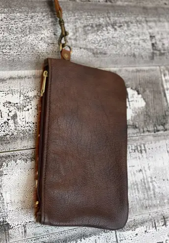 Brown cowhide with gold acid wash. 10”x6” wristlet with removable strap.