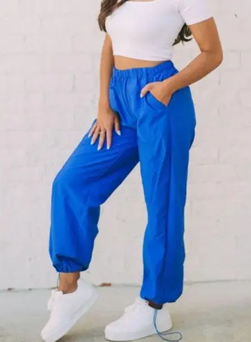 These Three Boutique. High-rise pant. Windbreaker material. Has pockets and can be worn as joggers or straight-leg style! Color: Blue. Size: Small.