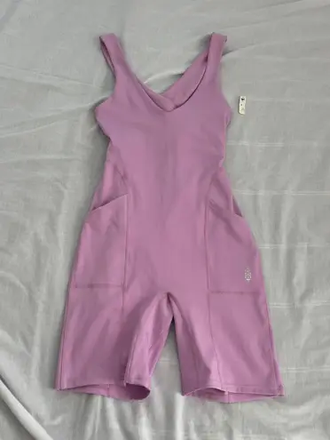 Free People Movement Here On Out Strappy Onesie Romper   Size XS  Condition: NWT  Color: bright orchid   Details : - See photo for approx. inseam measurement laying flat  - Built-in bra - not padded - Side pockets.