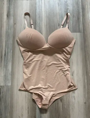 Spanx Assets Size Large, nude in color, built in convertible bra adjustable straps, pit to pit is 5, length from top to bottom is 19