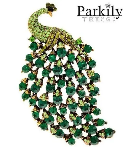 Brooch peacock in sparkly emerald green crystals in a gold and black pin