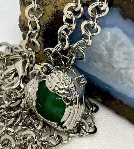 Green gemstone in a winged heart shaped necklace cage. 36”chain. Heart opens