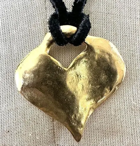 Gold tone heart pendant necklace on black cord