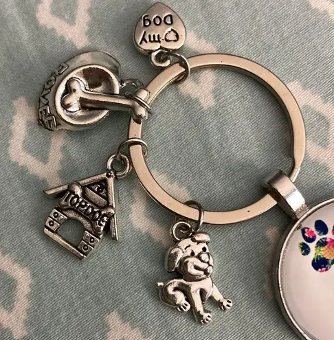 Puppy Keychain NWOT. Paw prints, dog house, dog, name tag and food dish charms.