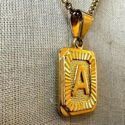 Gold tone A monogram pendant necklace