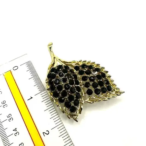 Black beaded gold tone double leaf brooch
