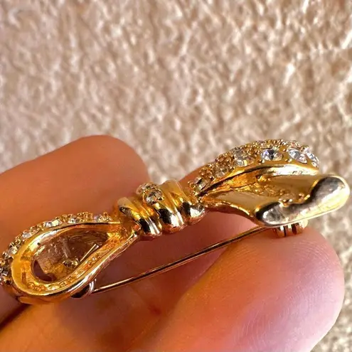 Roman gold tone rhinestone bow brooch