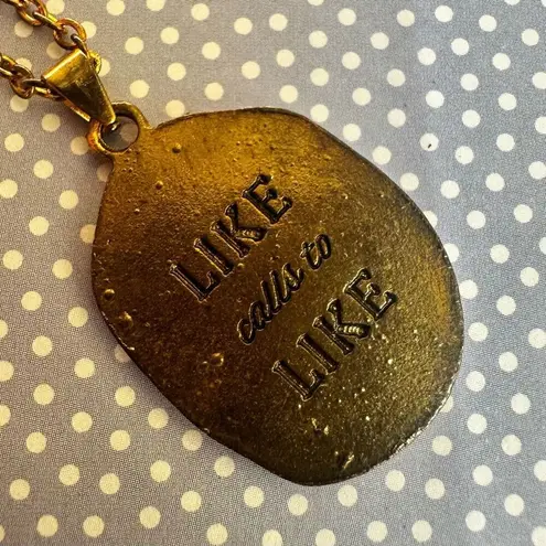 Like calls to Like gold tone and black starburst pendant necklace