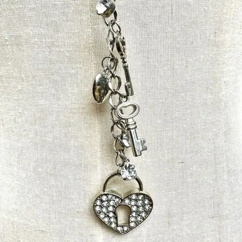 Silver tone heart and key long charm necklace