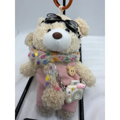 Adorable fluffy black monster keychain with big cartoon eyes and white feet.