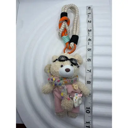 Adorable fluffy black monster keychain with big cartoon eyes and white feet.