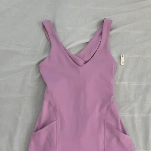 Free People Movement Here On Out Strappy Onesie Romper   Size XS  Condition: NWT  Color: bright orchid   Details : - See photo for approx. inseam measurement laying flat  - Built-in bra - not padded - Side pockets.