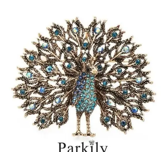 Brooch peacock in sparkly blue and aqua crystals in a gold tone pin setting