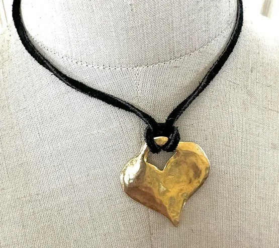 Gold tone heart pendant necklace on black cord
