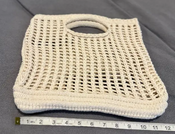 None handmade cream-colored, open-knit crochet tote bag with built-in handles.