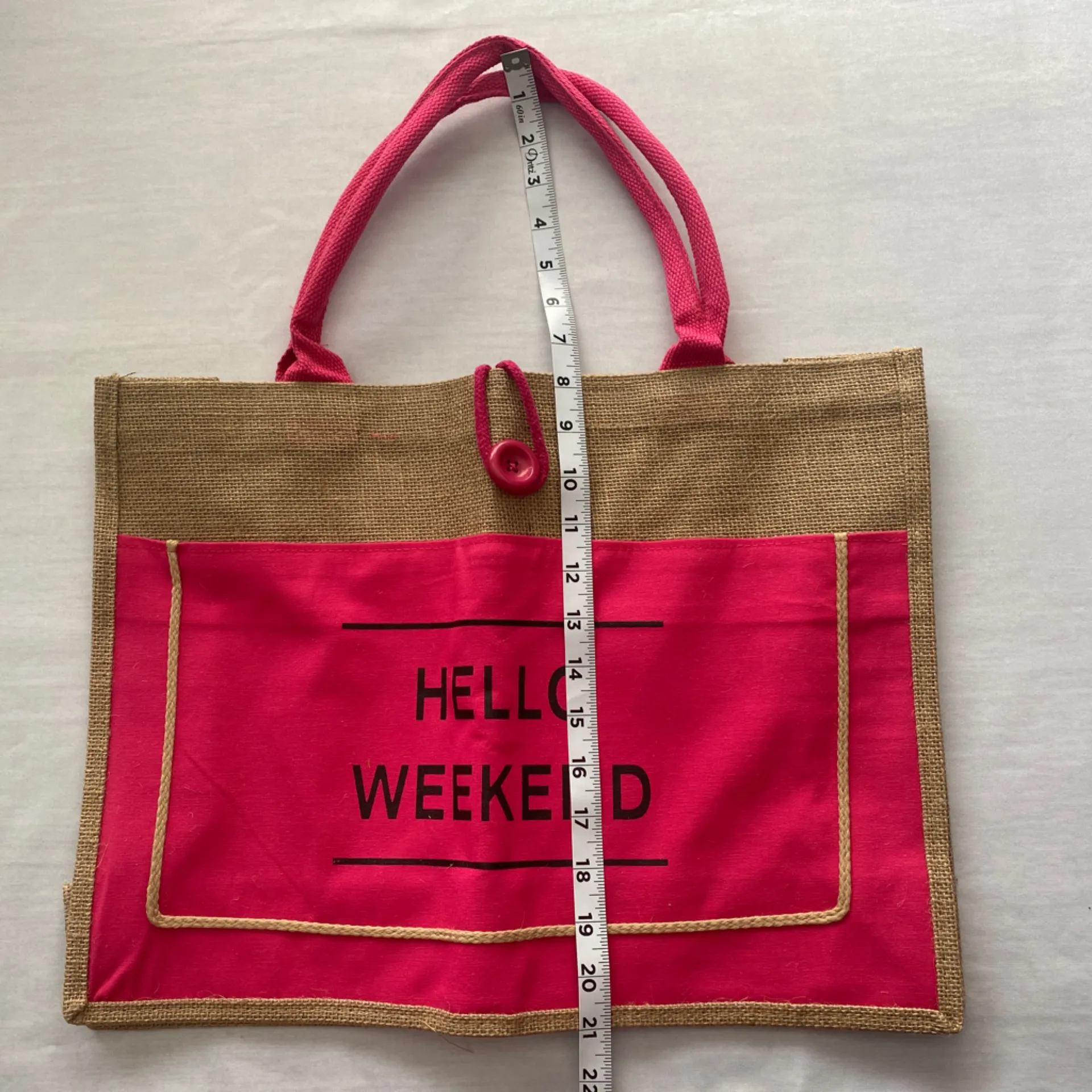 Jute Pink Tote‎ Bag Hello Weekend
Button loop closure
13.5” x 18” Tan - Image 5