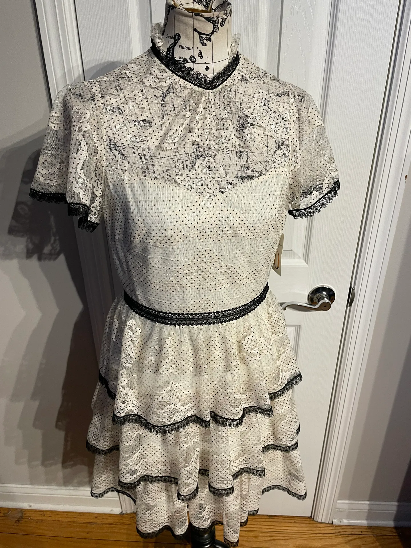 Stacia Lace Tiered Polka Dot Knee Length High Neck Black trim on neck/sleeve/bottom Hidden back zipper A flutter sleeve ballet lace fit-and-flare mini dress with ruffle detail below the waist ivory cream Kentucky Derby mock sheer layer - Image 4
