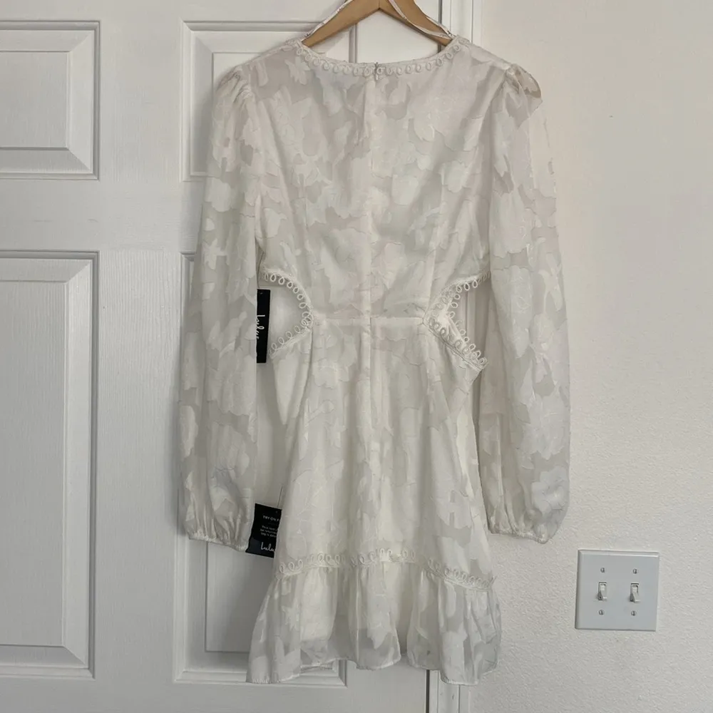 Lulu’s white cutout mini dress with sheer sleeves. - Image 2