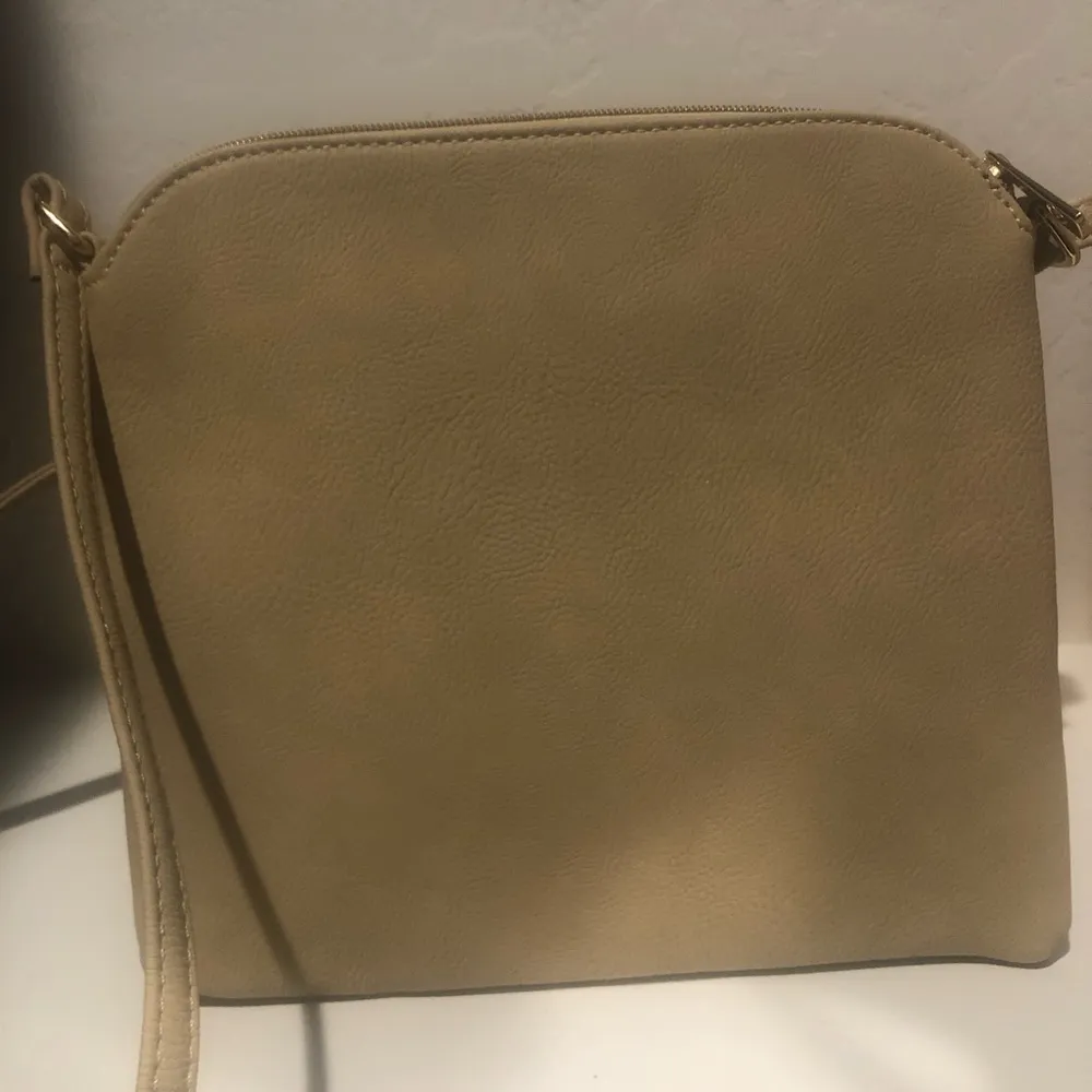 Lightweight med. crossbody shoulder bag with tassel and zipper in tan and black - Image 3