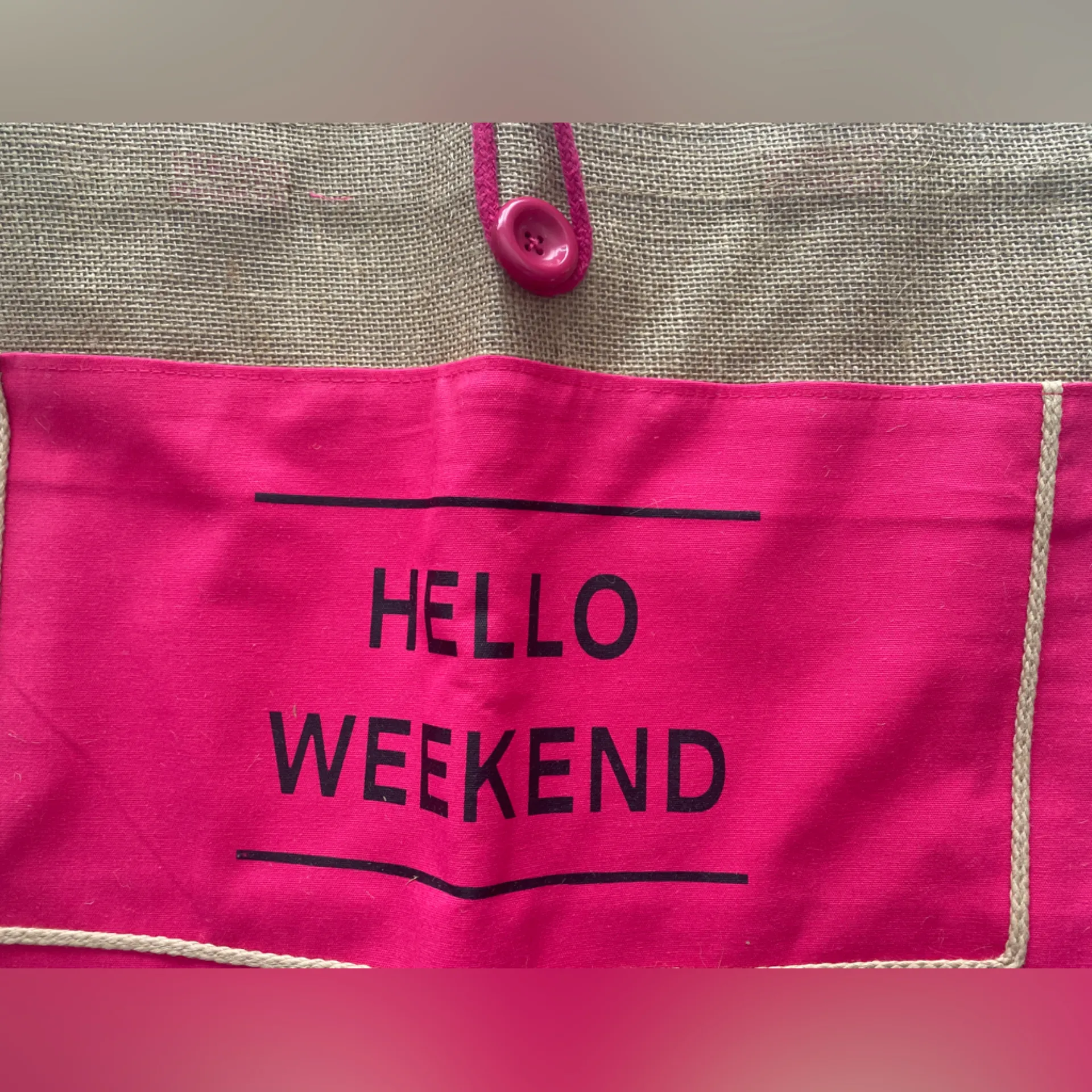 Jute Pink Tote‎ Bag Hello Weekend
Button loop closure
13.5” x 18” Tan - Image 6