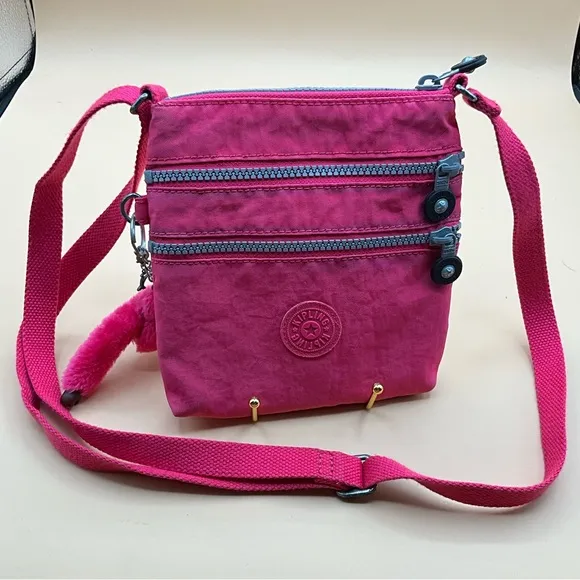 A Cute Bright Pink 3 Zip Nylon Kipling Crossbody Handbag With Monkey - Image 1