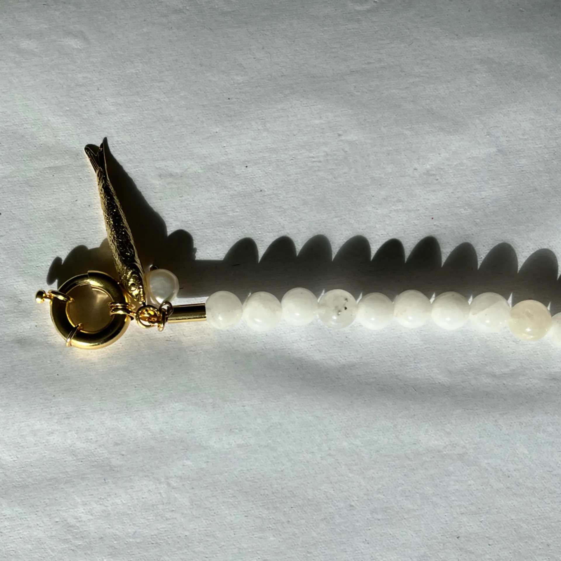 Gaby's White Beaded Necklace with Gold Fish Charm - Image 9