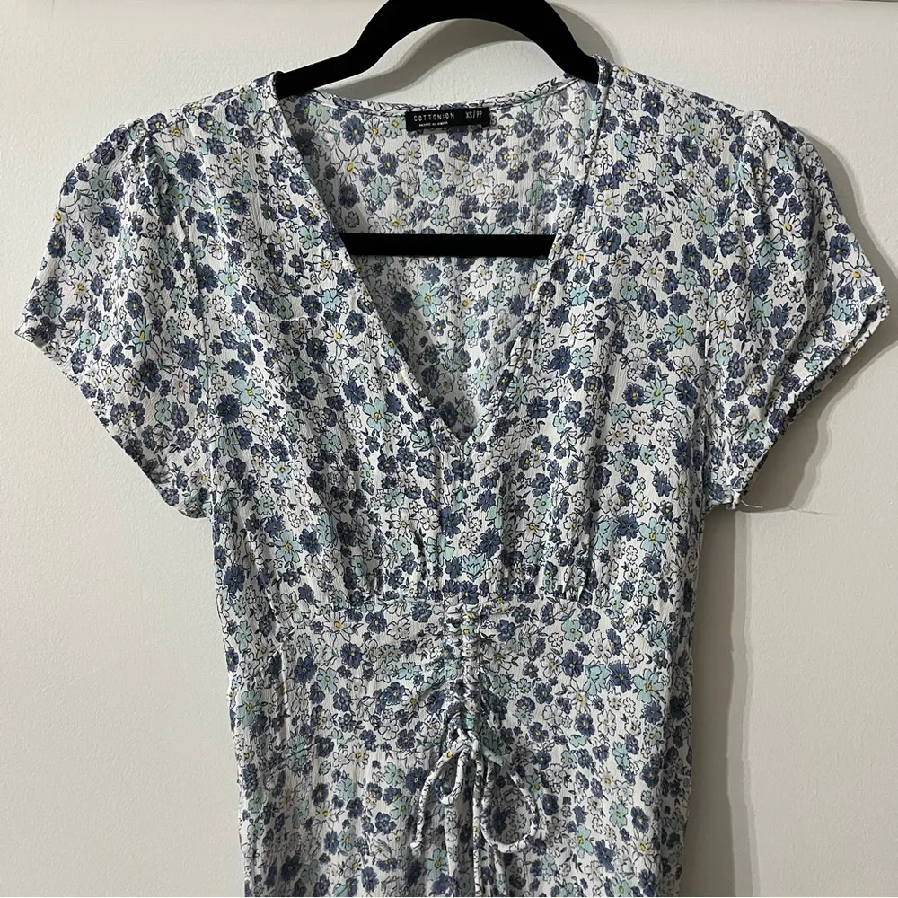 White dress with blue flowers. Little pull tie in the front 100% viscose. I - Image 3